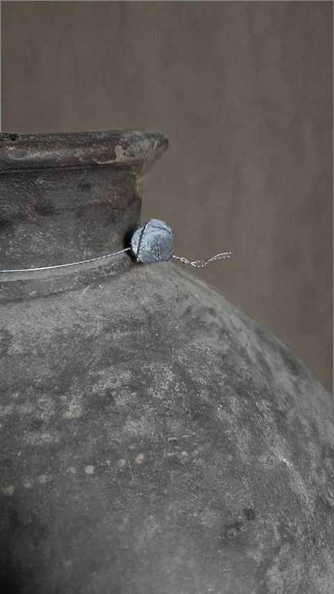 Oude aardewerken bolkruik op metalen voet, detail 3