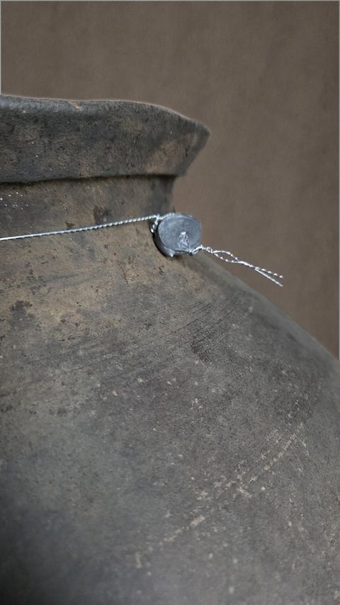 Oude aardewerken bolkruik op metalen voet, detail 3