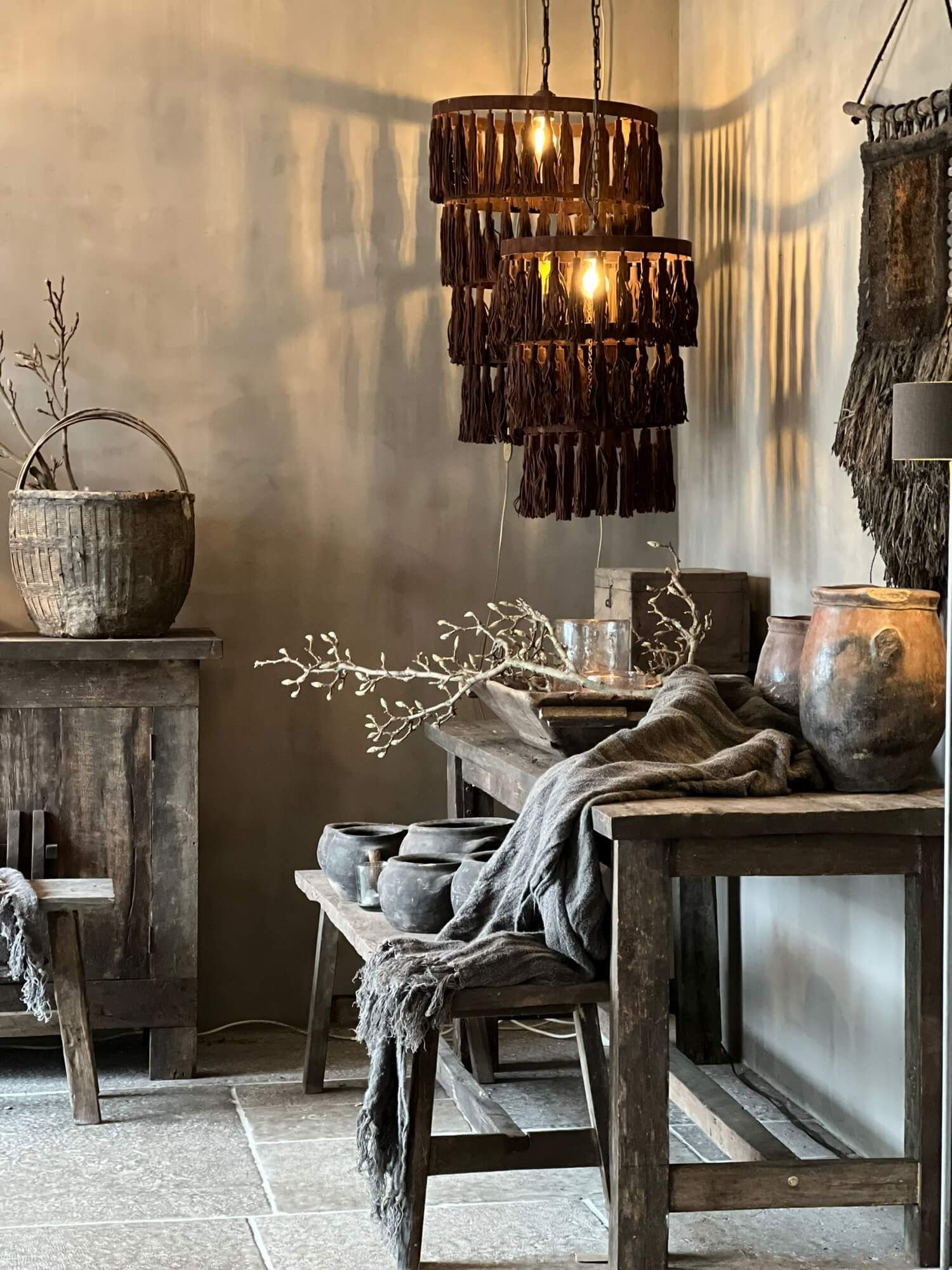 Houten hanglampen van Aura Peeperkorn boven een tafel met oude potten