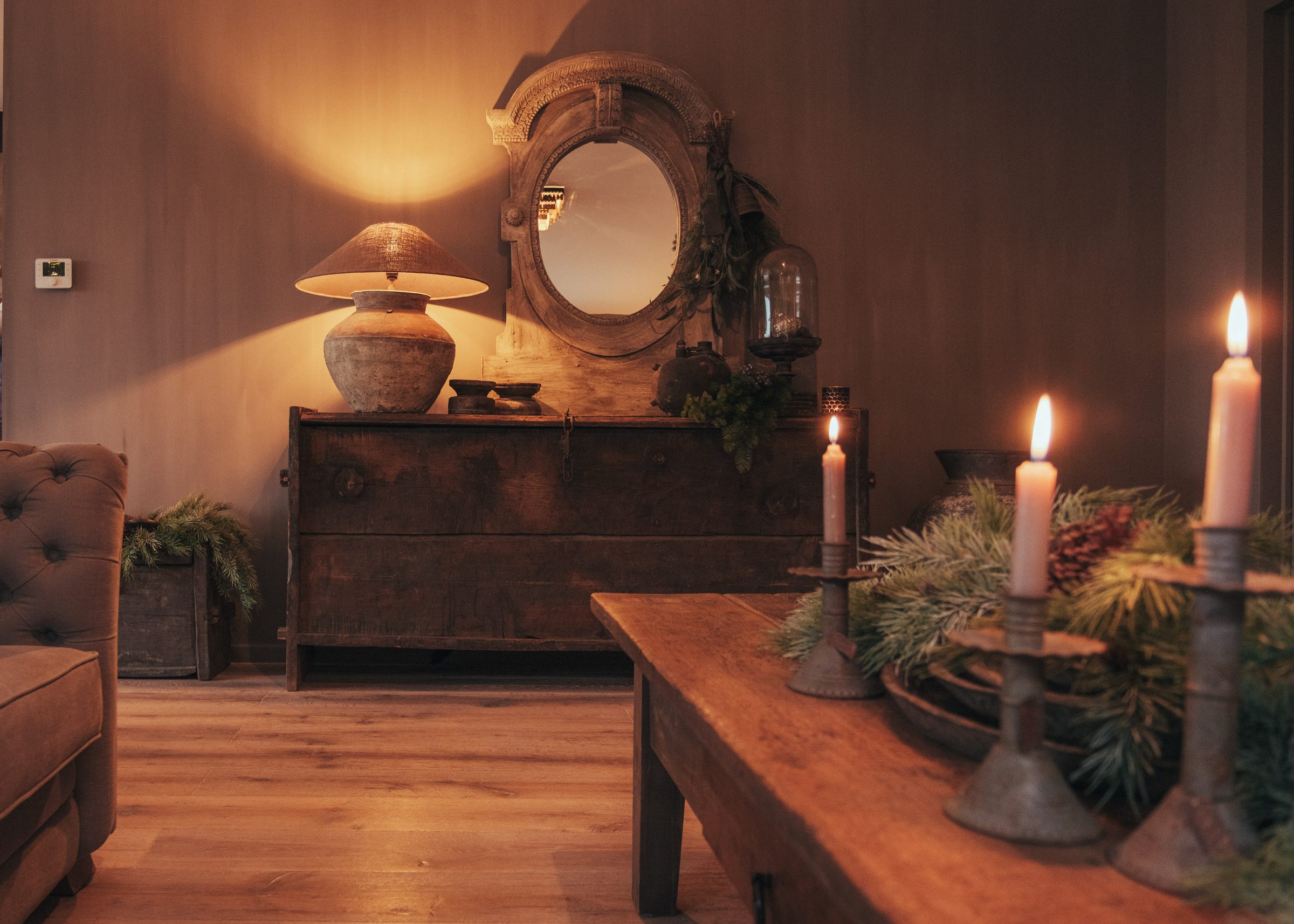 Dressoir met ovale spiegel, pottenlamp en kaarslicht in kerstsfeer — Nina 2025