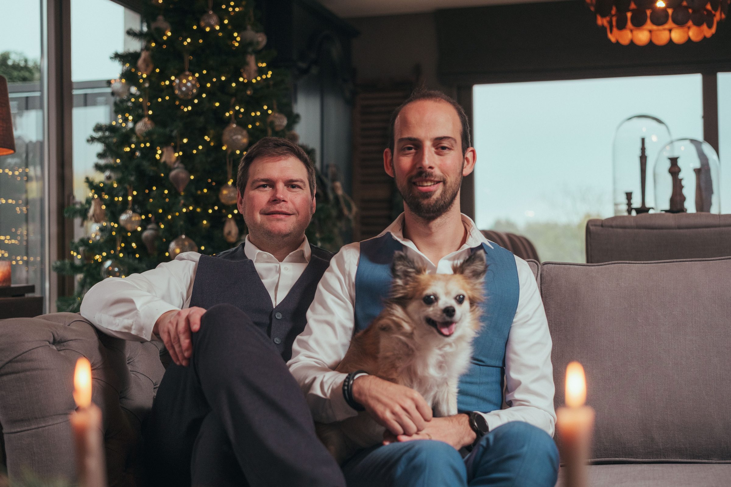 Jelle en Daan met hun hondje op de sofa bij kaarslicht — Nina 2025