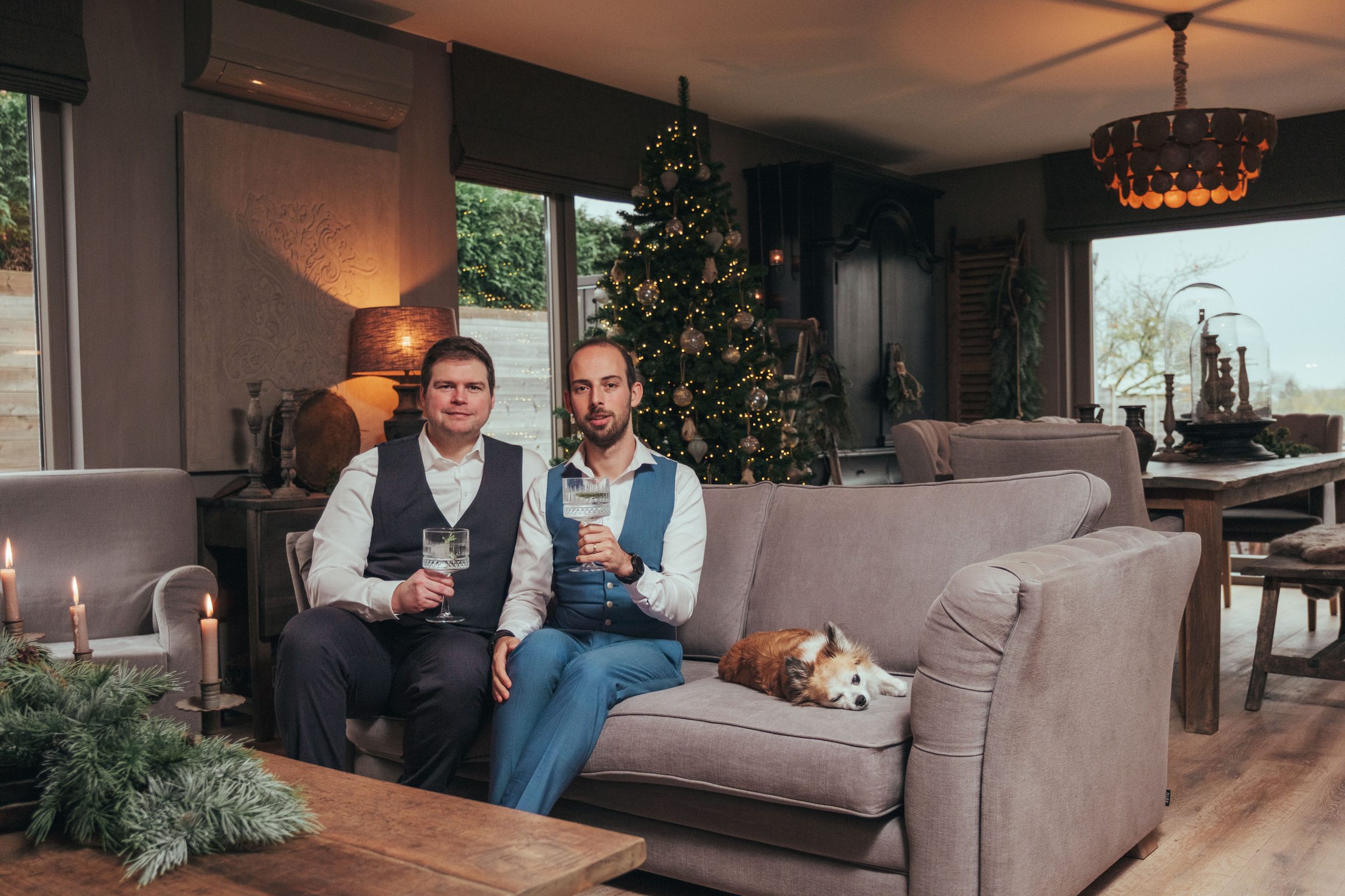 Jelle en Daan met hun hondje op de sofa, woonportret in Nina kersteditie 2025