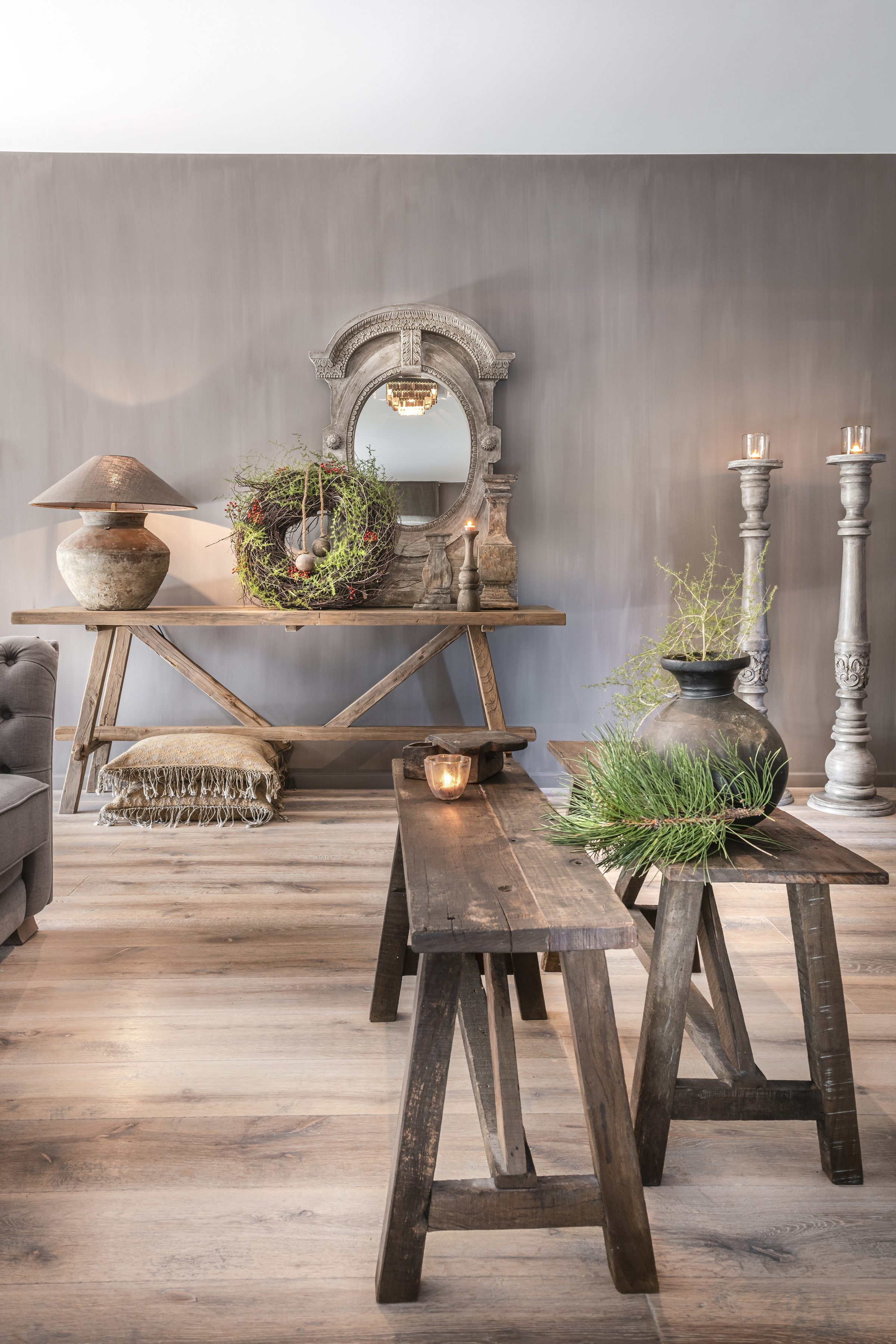Heldere winkelhoek met houten wandtafel, spiegel en bankjes