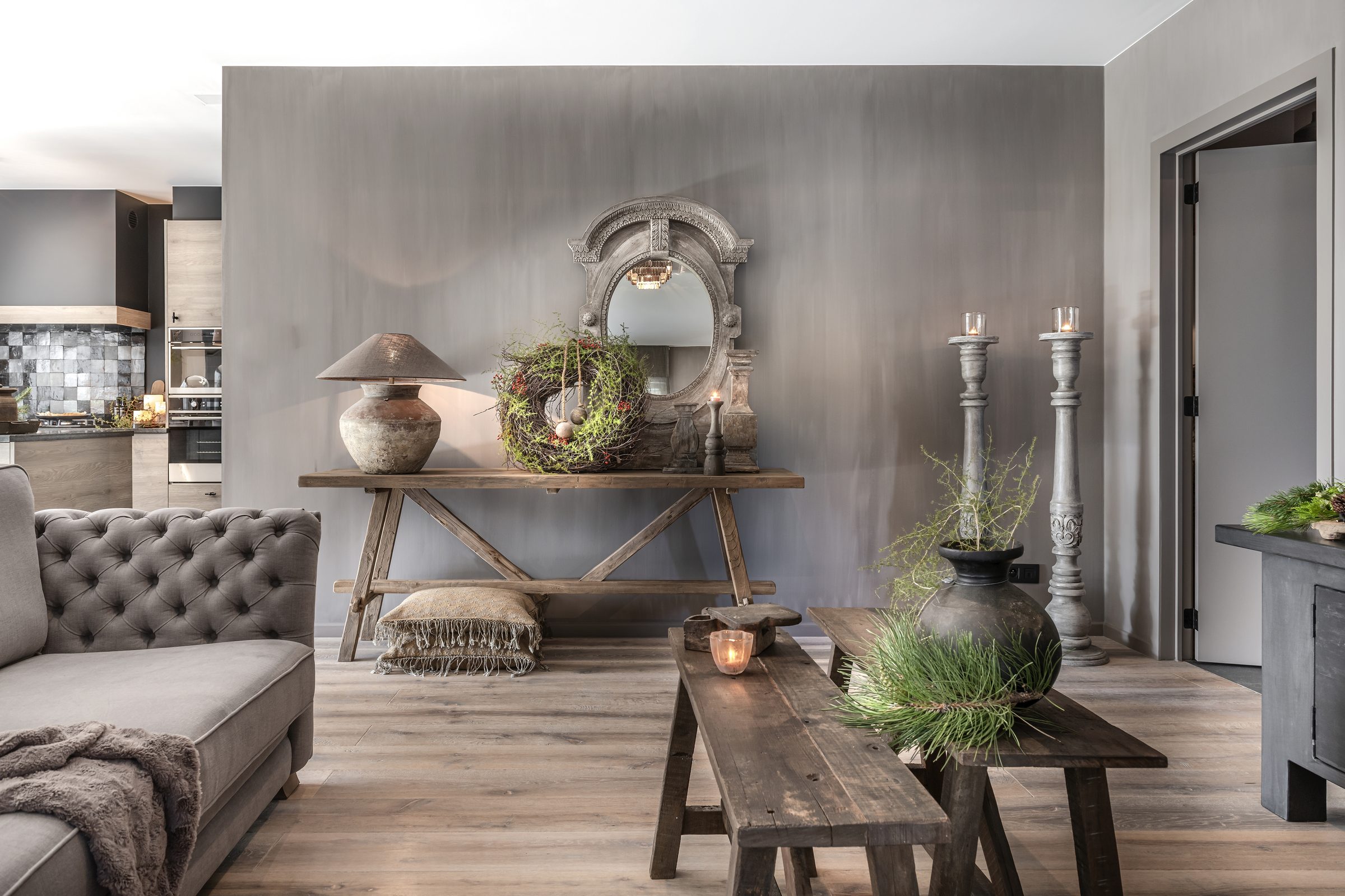 Heldere wand met houten wandtafel, spiegel en zachte sofa
