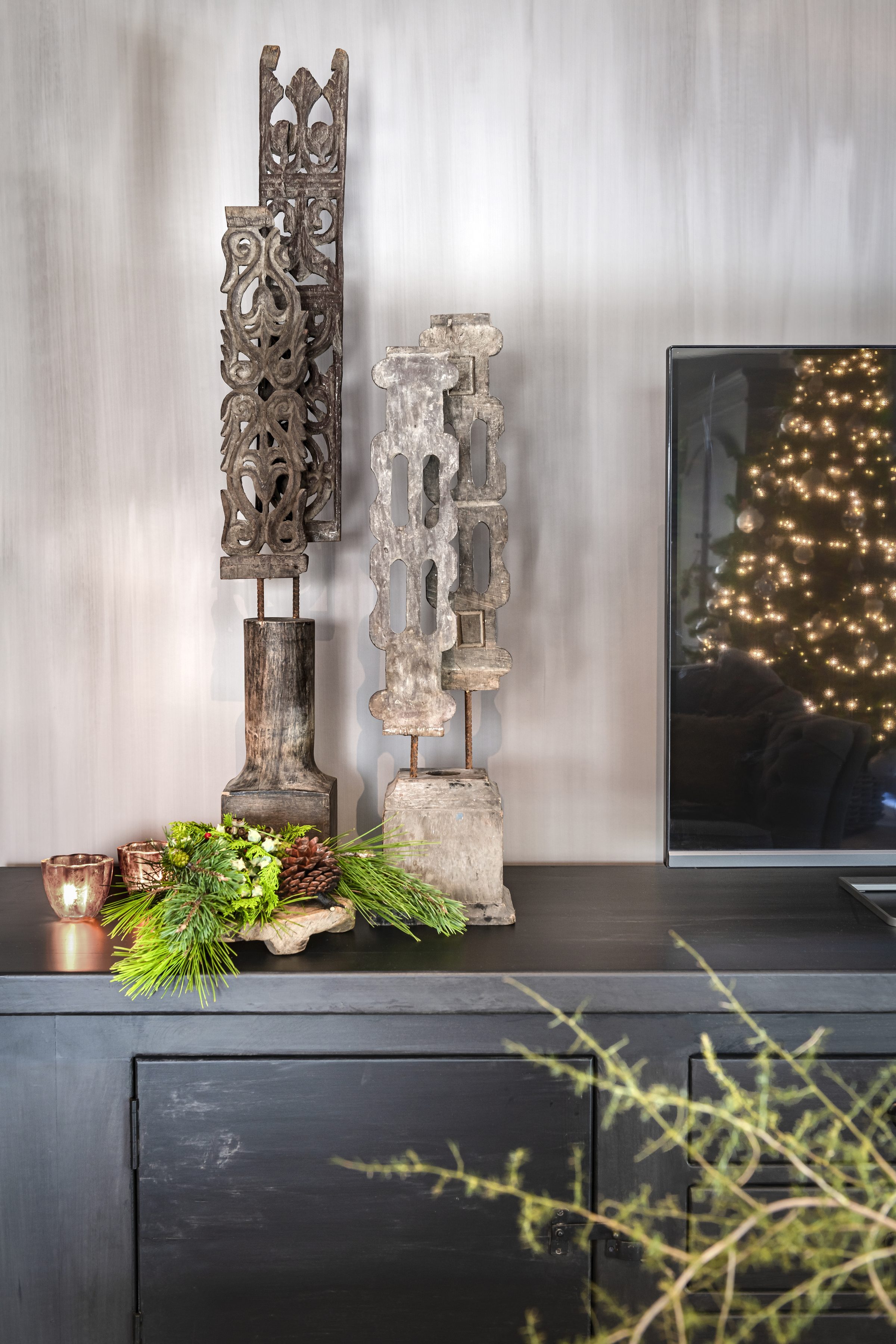 Handgesneden houten ornamenten op zwart dressoir — Aura Peeperkorn