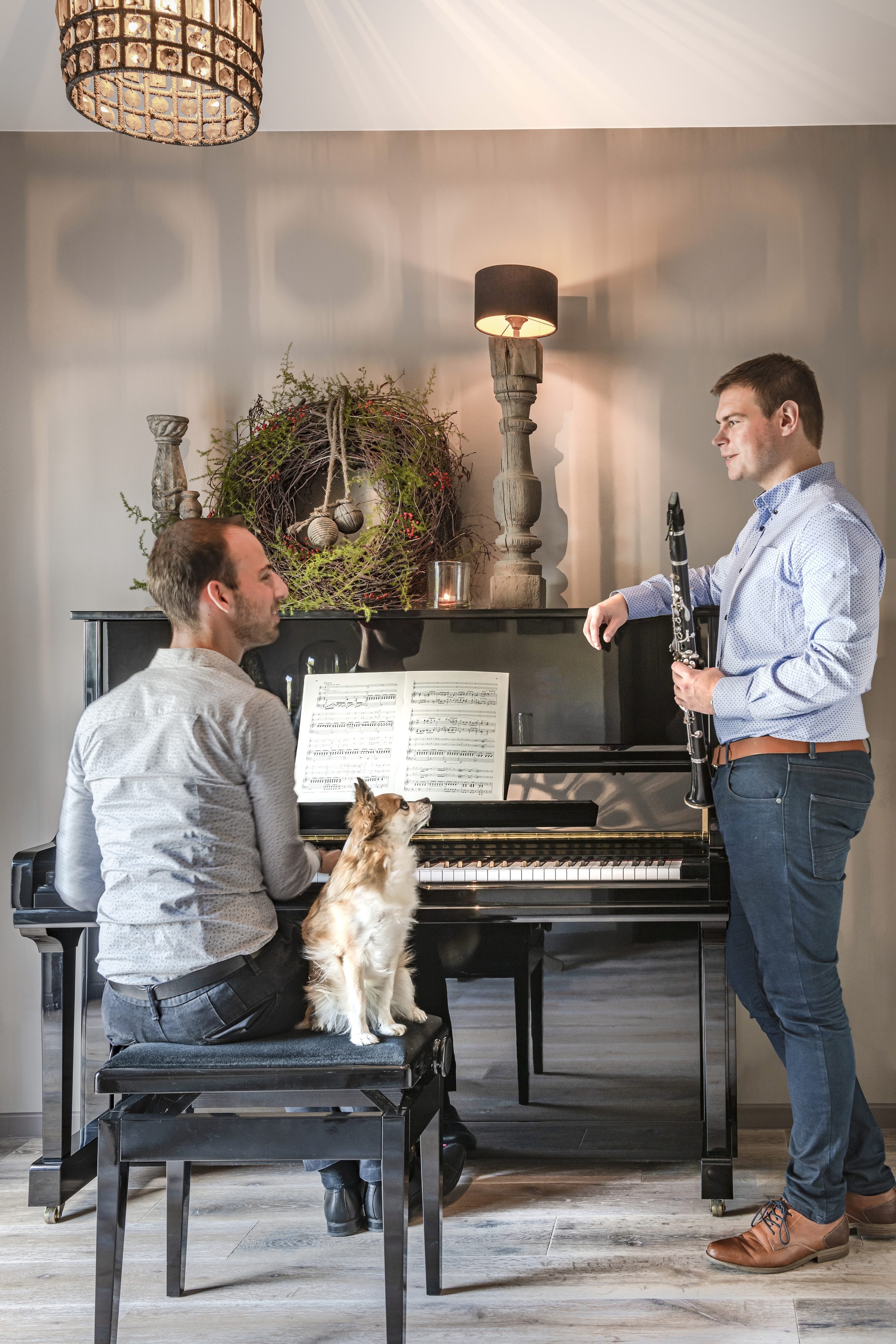 Jelle en Daan samen aan de piano, met hun hondje op de pianobank