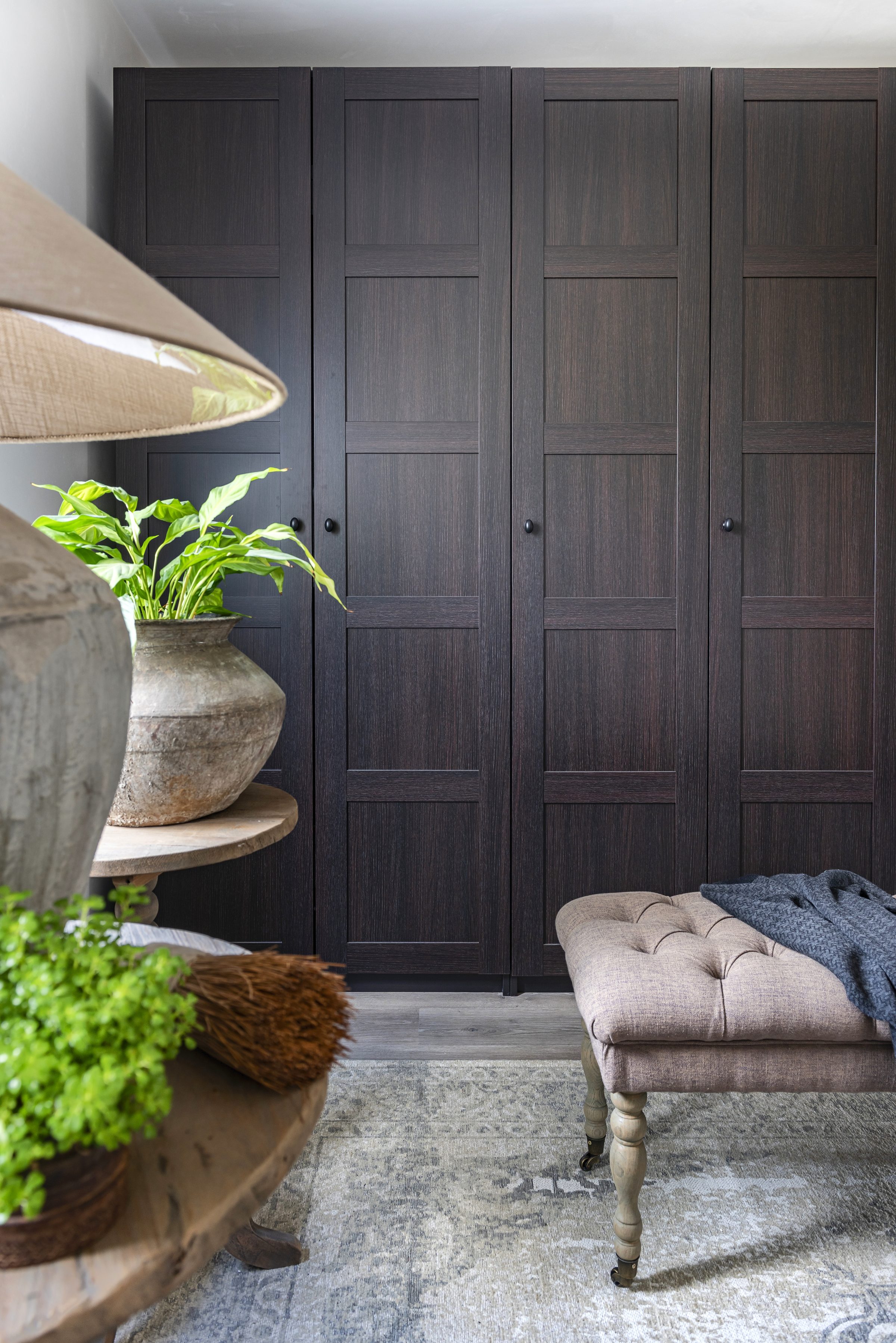 Donkere houten kastenwand met antieke pot en plant